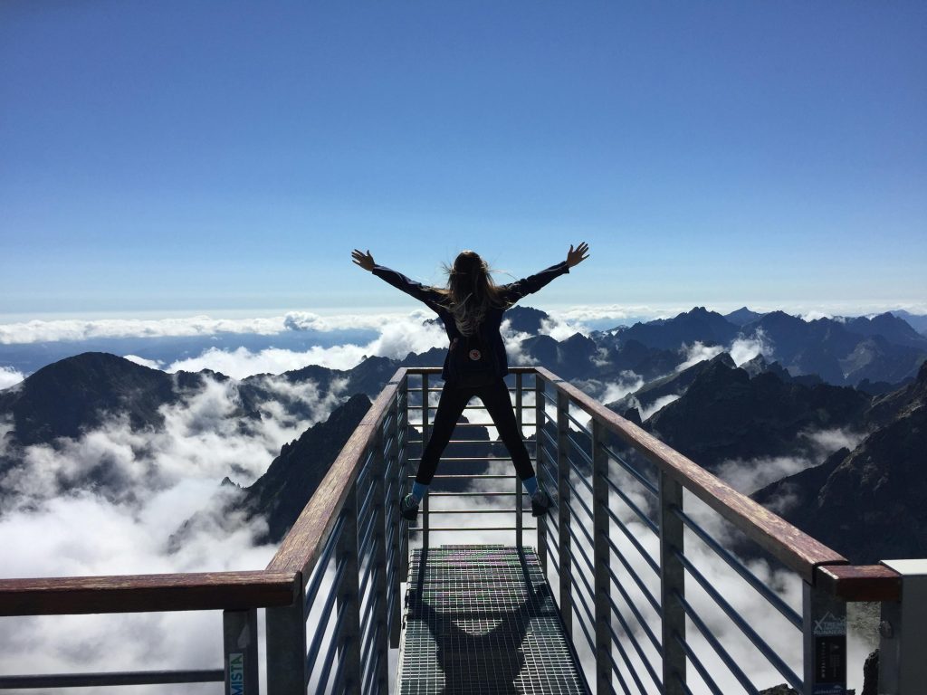 Person standing triumphantly on mountain peak