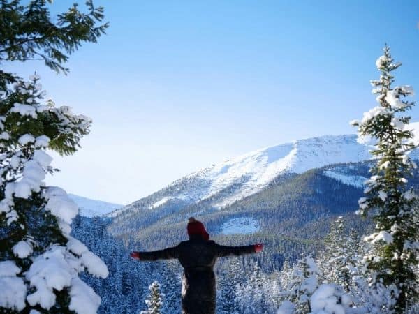 Person enjoying snowy mountain landscape.