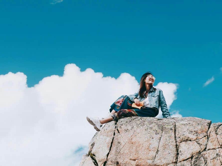 personal growth self reflection open sky Person sitting on rocks under an open sky representing self-reflection and personal growth