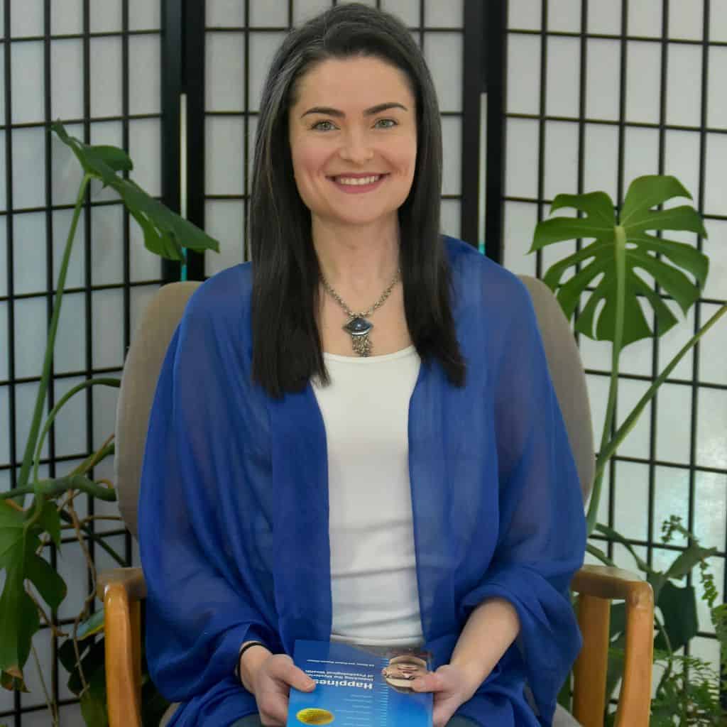 Life coach Mary Simon seated indoors, smiling warmly in a calm, welcoming setting.